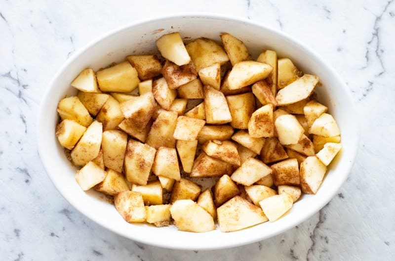 Apples for apple crumble coated in brown sugar and cinnamon.