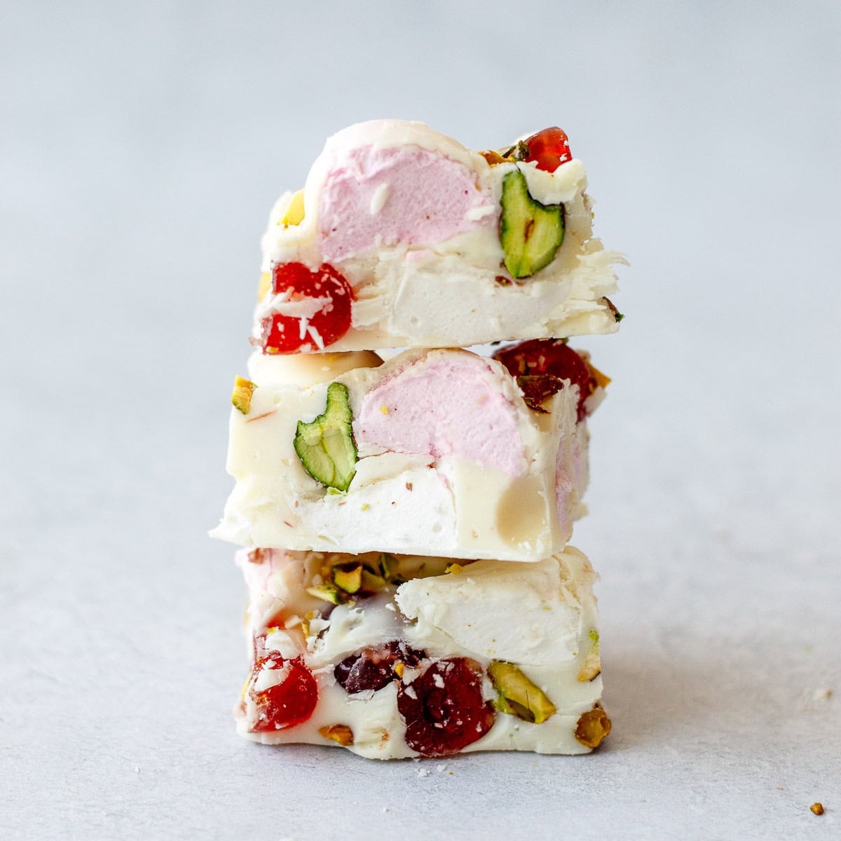 3 squares of white chocolate rocky road stacked on top of each other.
