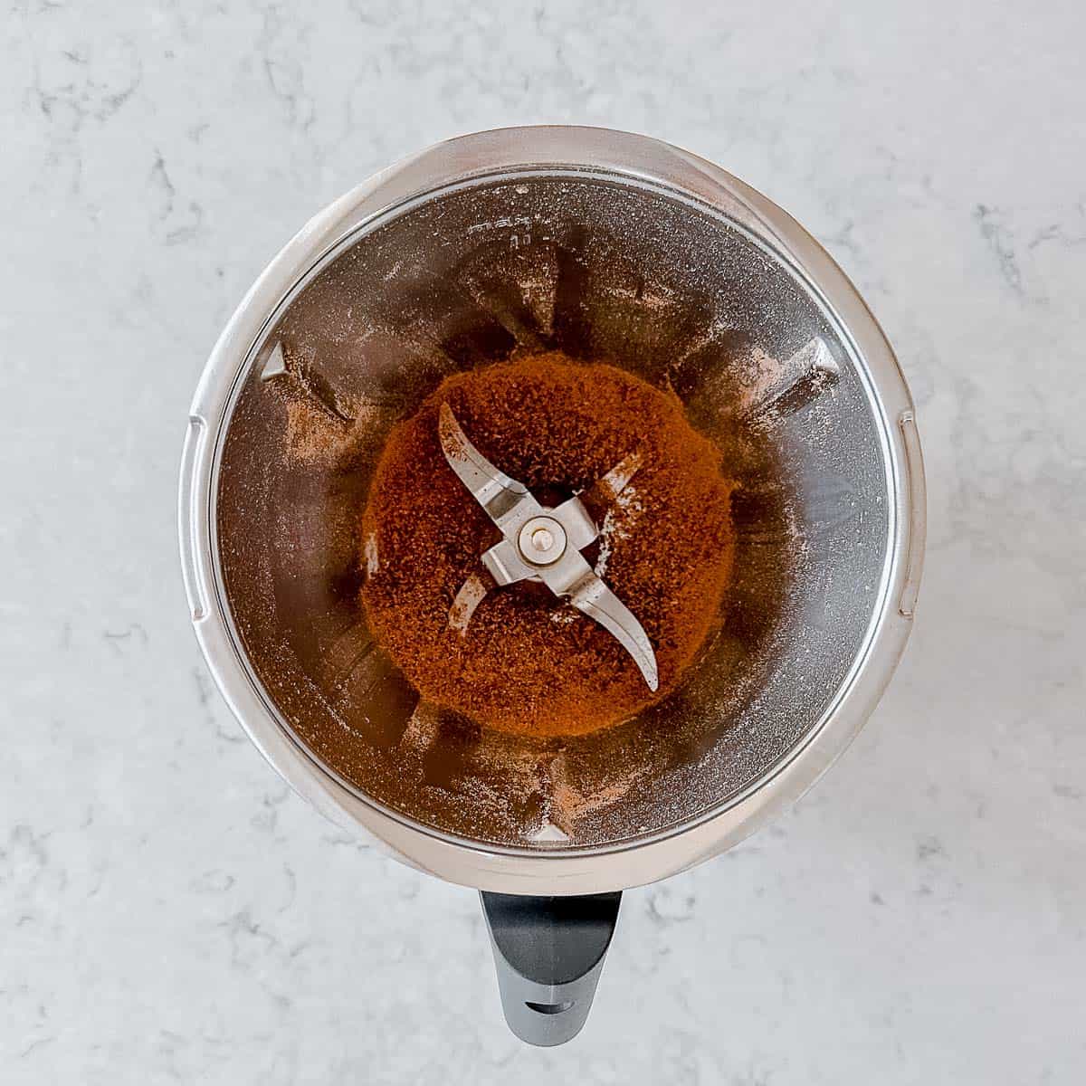 Overhead image of grated chocolate in a Thermomix bowl.