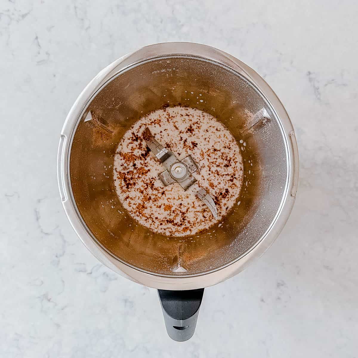 Chocolate and milk in a Thermomix bowl.