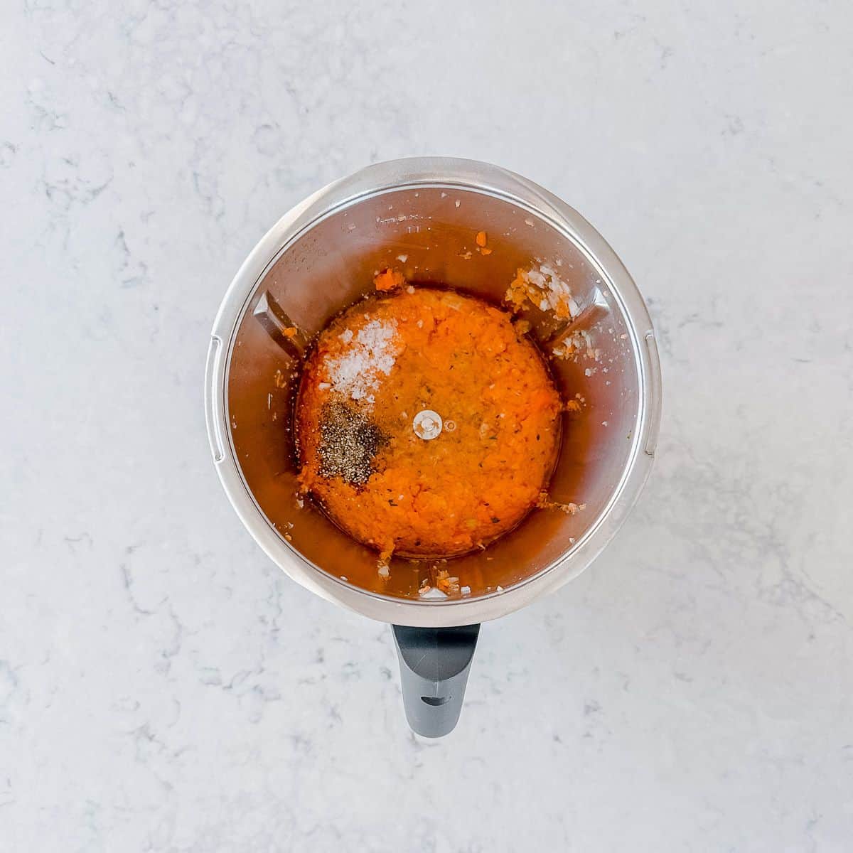 Grated carrots, salt and pepper in a thermomix bowl.