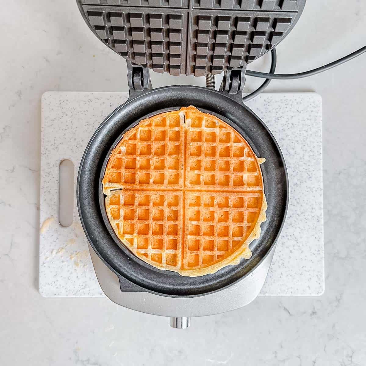 Cooked waffles in a waffle iron.