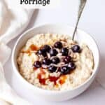 Porridge in a white bowl with sunflower seeds and blueberries.