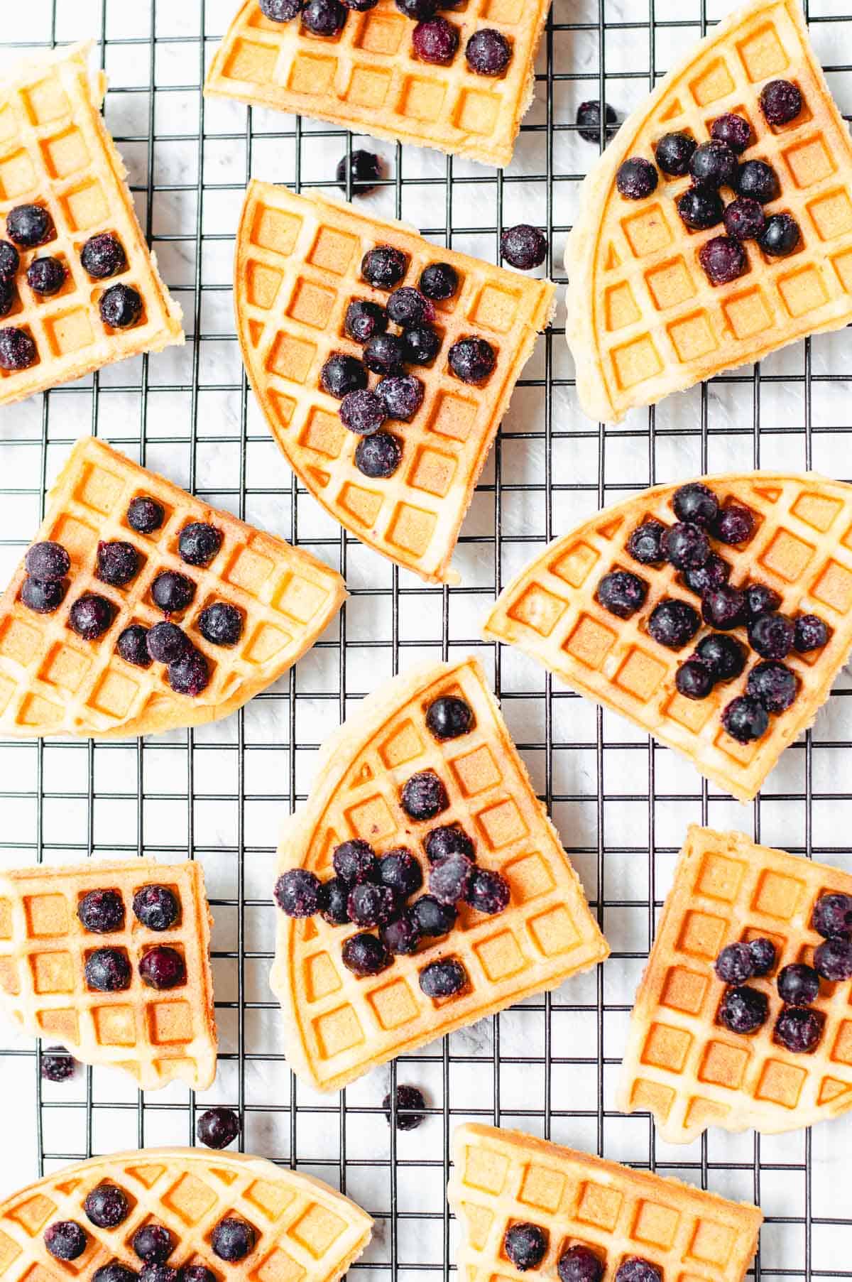 waffles on a wire rack topped with blueberries.