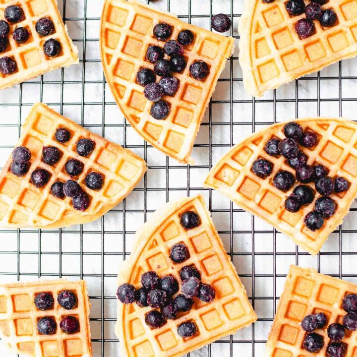 waffles topped with blueberries sitting on a baking rack.