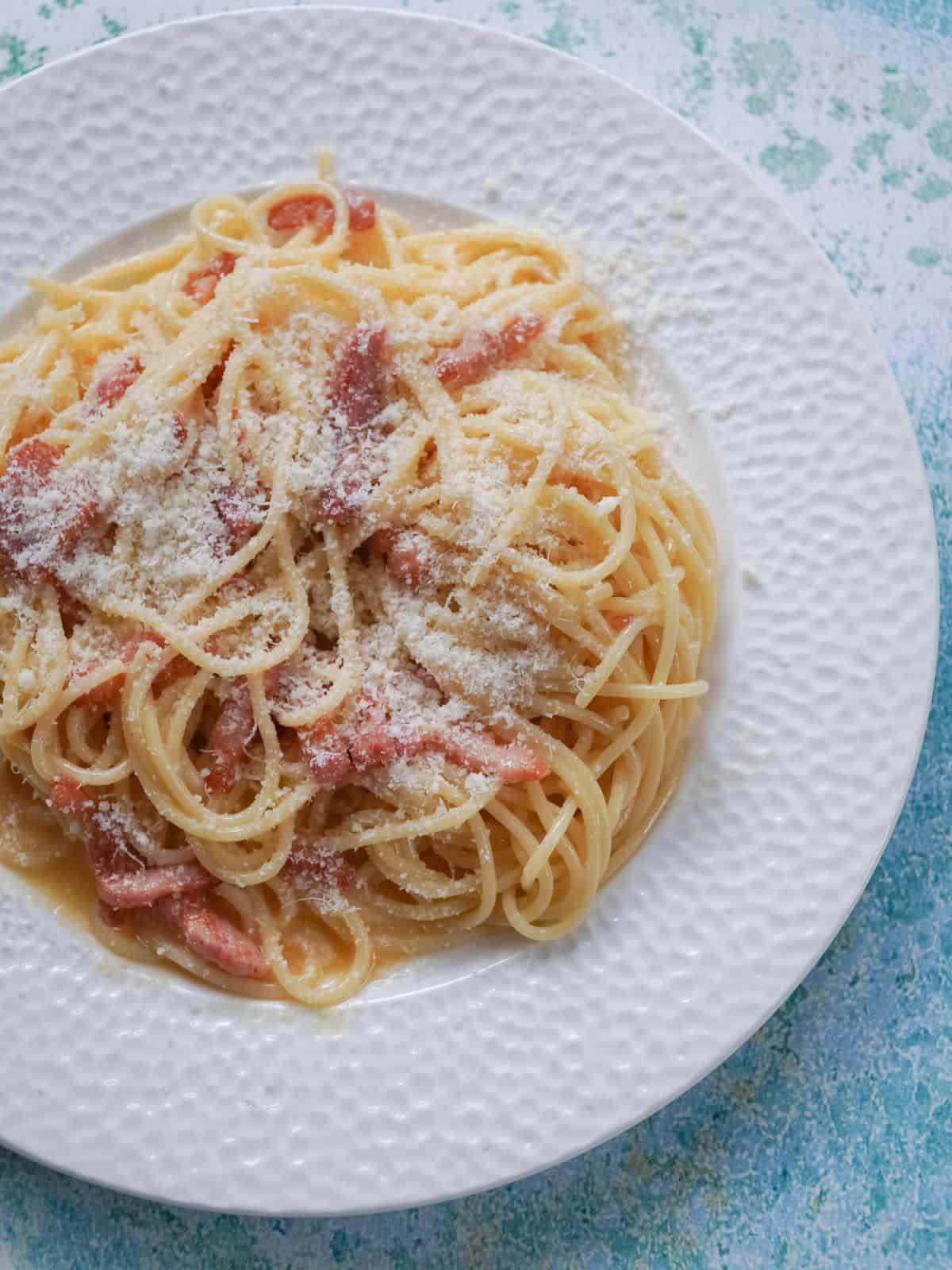 Pasta carbonara in a white dish.