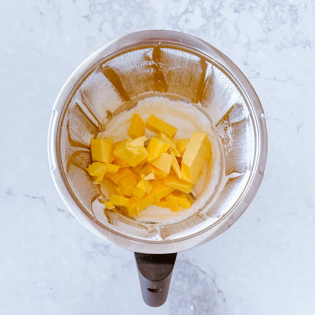 Butter and icing sugar in a Thermomix bowl.