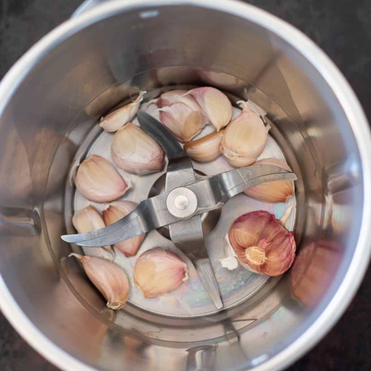 Garlic cloves in a Thermomix Bowl.