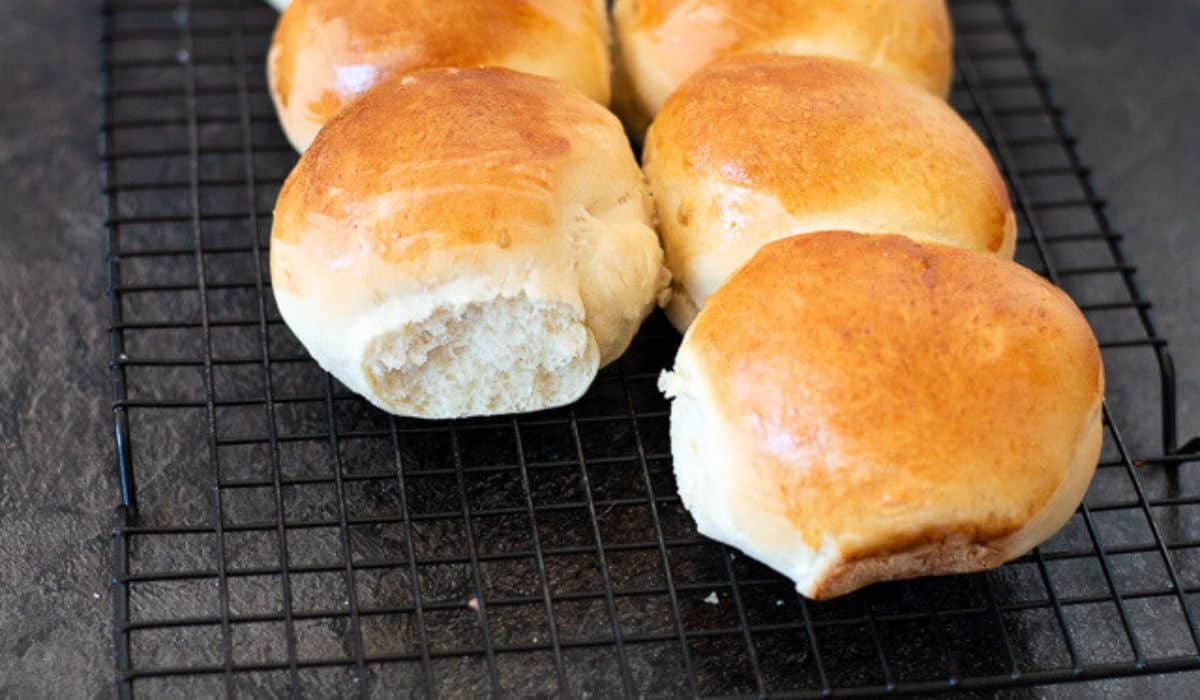 White bread rolls on a baking rack.