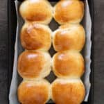 8 round bread rolls on a baking tray.
