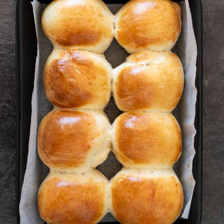 8 round bread rolls on a baking tray.