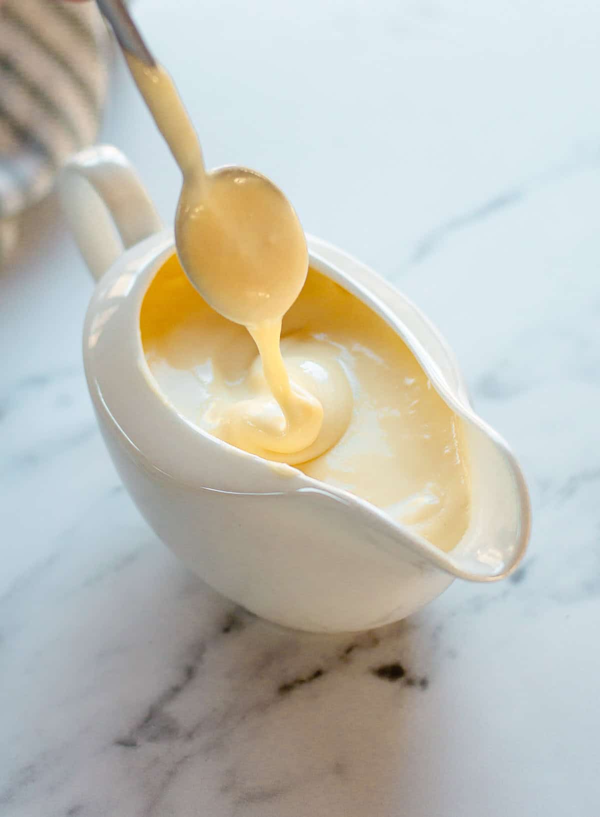 Cheese sauce in a white jug.