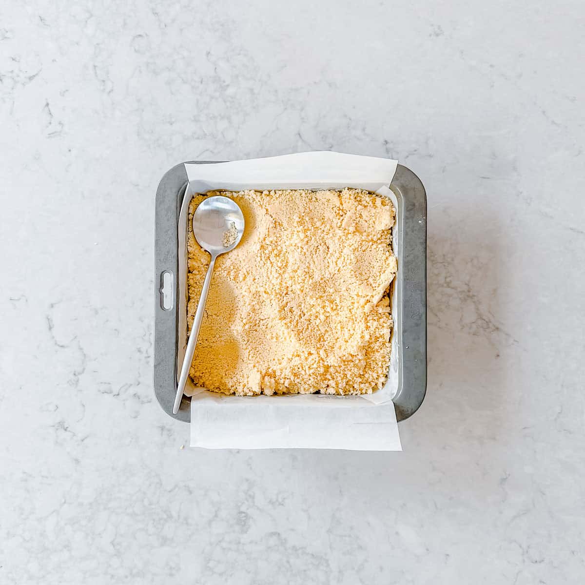 Shortbread mixture in a square baking tin.