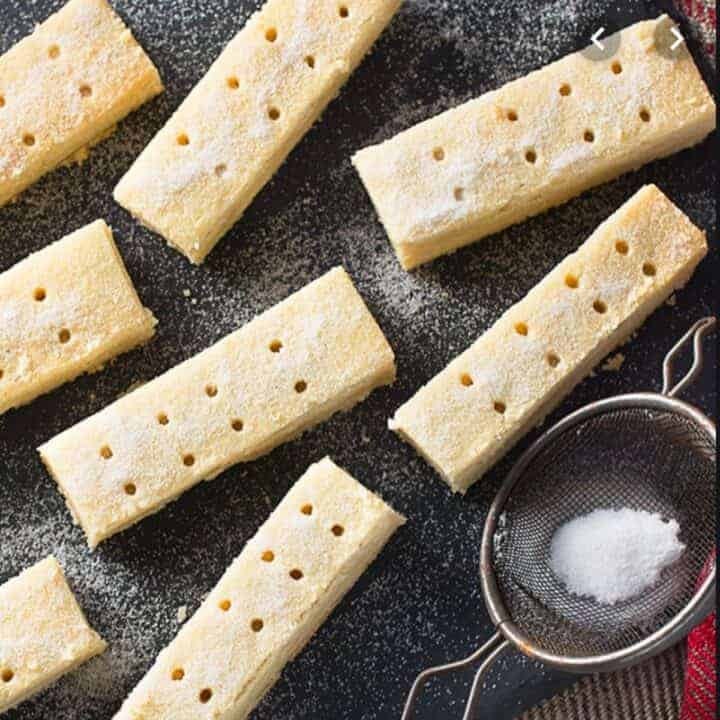 Overhead image of shortbread fingers sitting on a dark background.