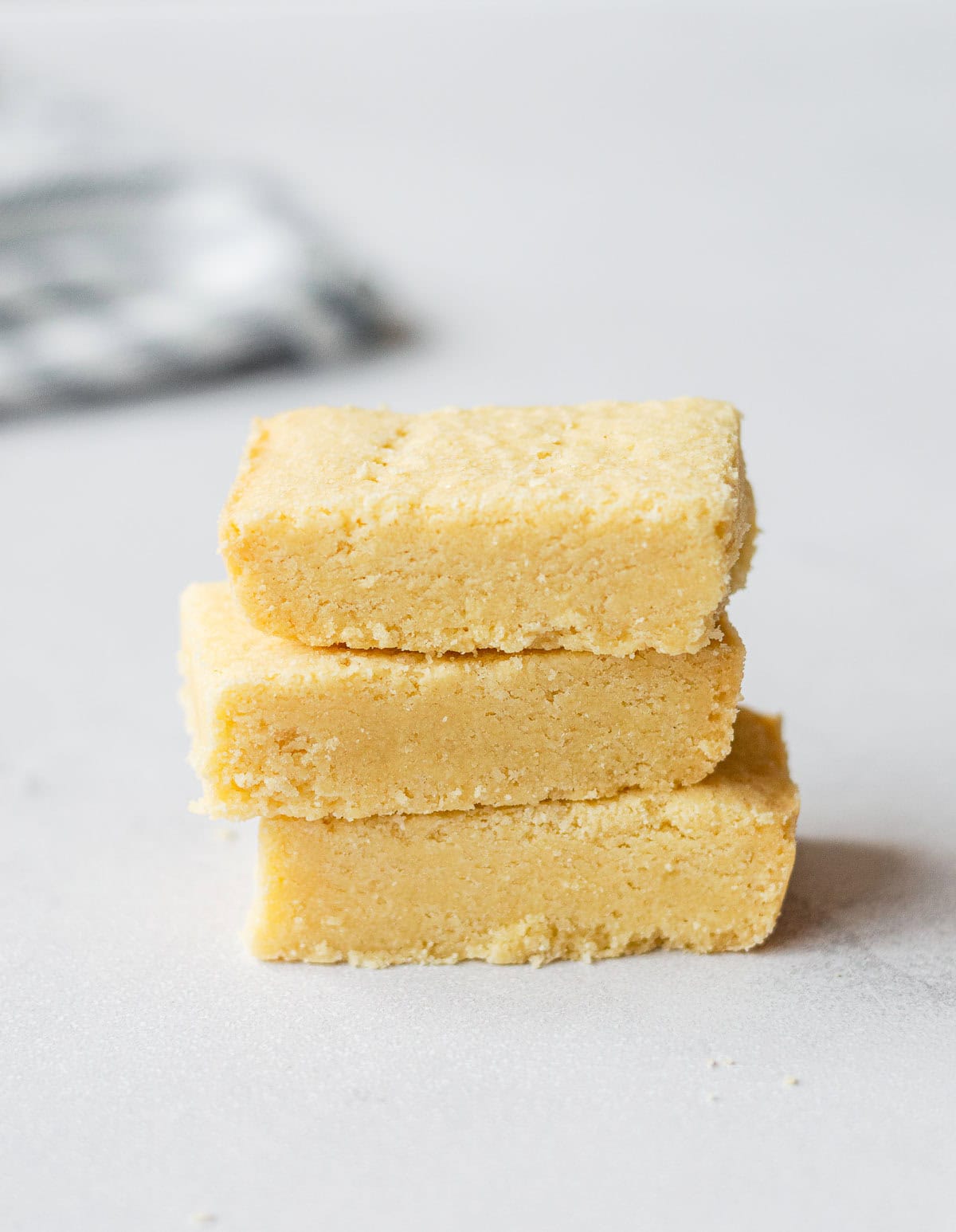 A stack of 3 shortbread squares on a pale background.
