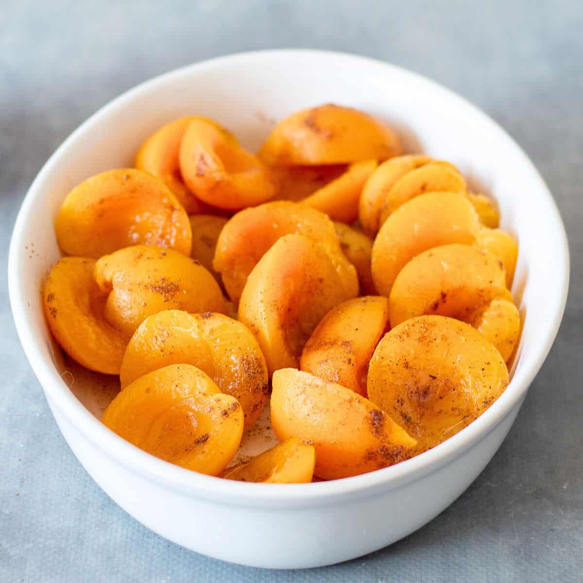 Apricots in a white oval dish.