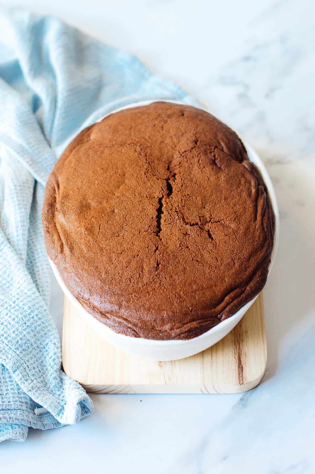 Chocolate pudding in a white oval dish on a pale background.