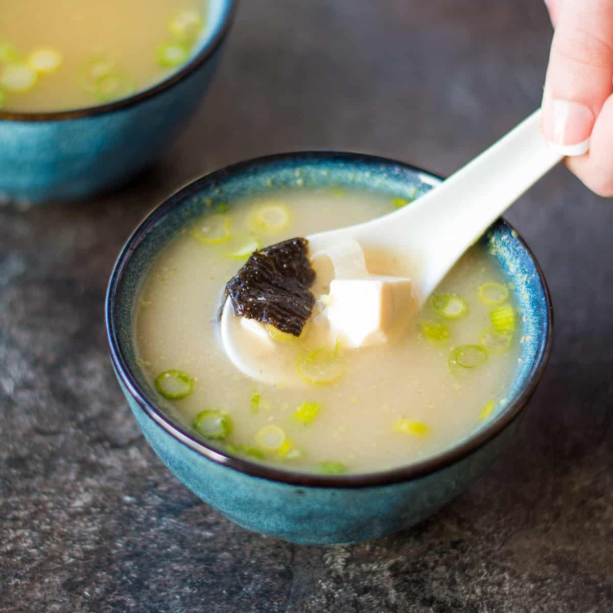 A bowl of miso soup with nori and tofu