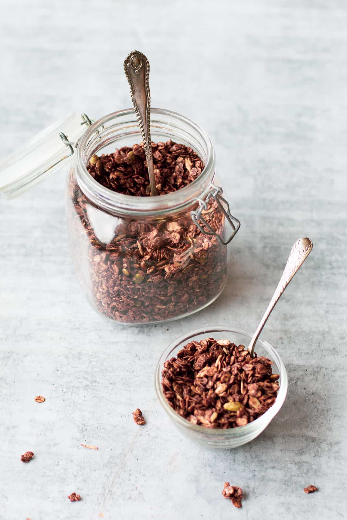 Homemade Chocolate Granola in a jar and small bowl with a spoon
