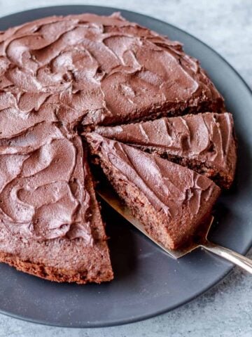 Chocolate Cake Covered in Chocolate Buttercream Icing Cut into Slices