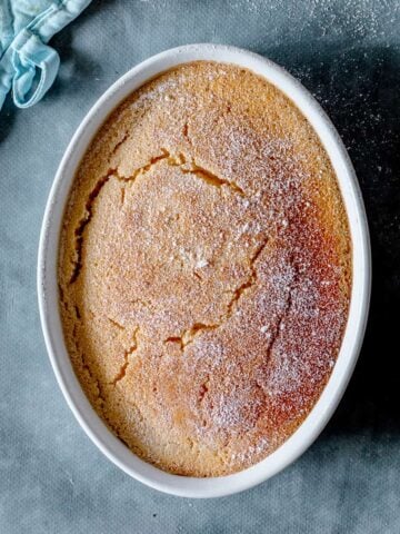 Lemon Delicious Pudding in Oval Shaped Bowl on blue background