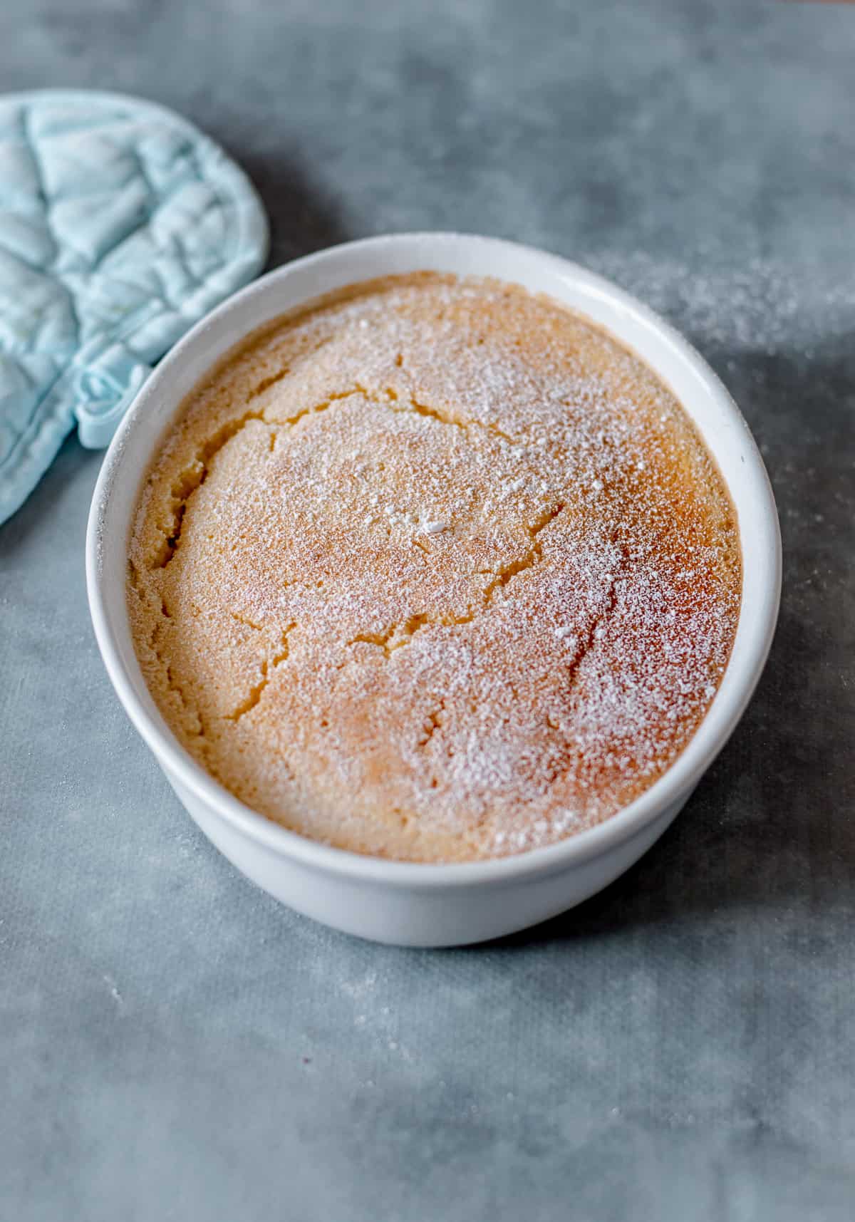 Lemon Delicious Pudding in an oval bowl on blue background