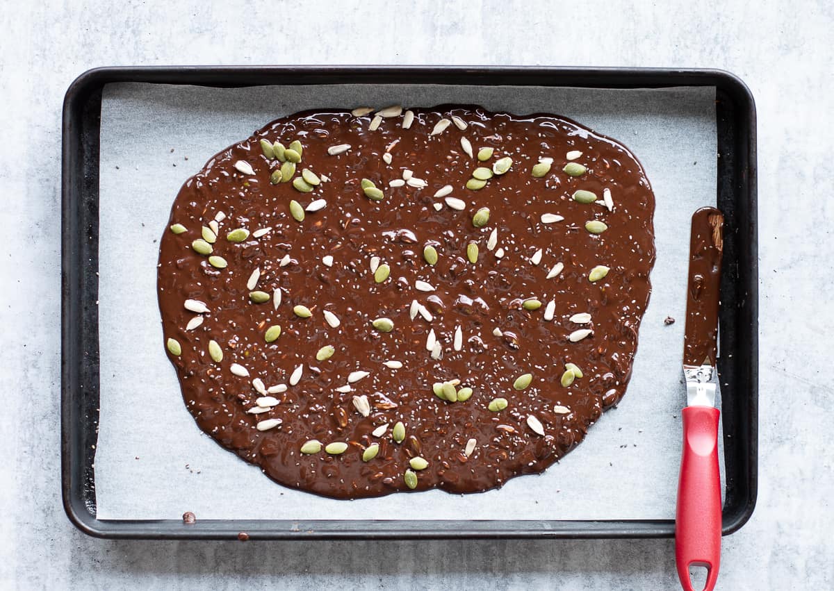 Melted dark chocolate covered with seeds.