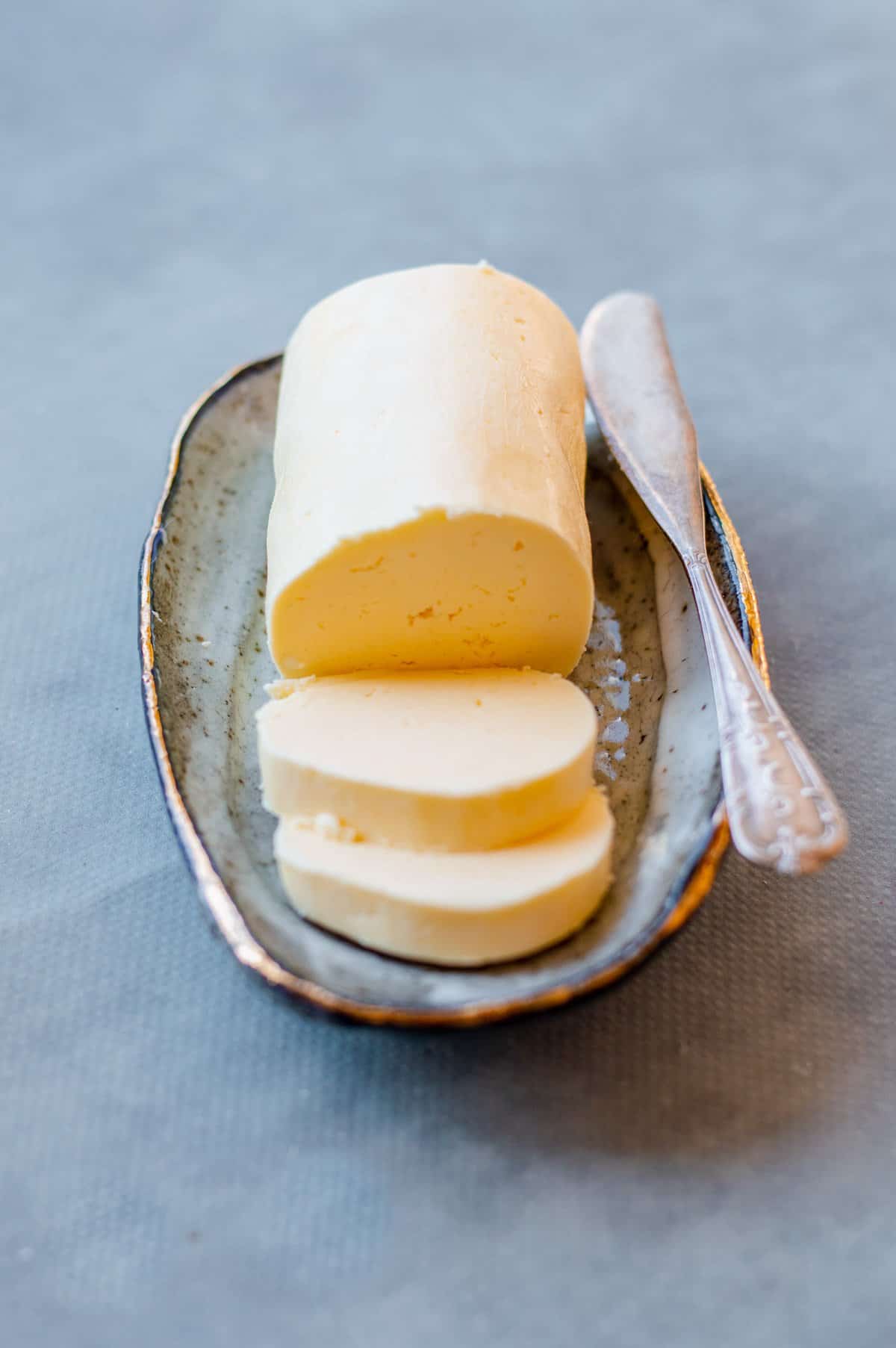 Close up image of sliced homemade butter on an oval dish.