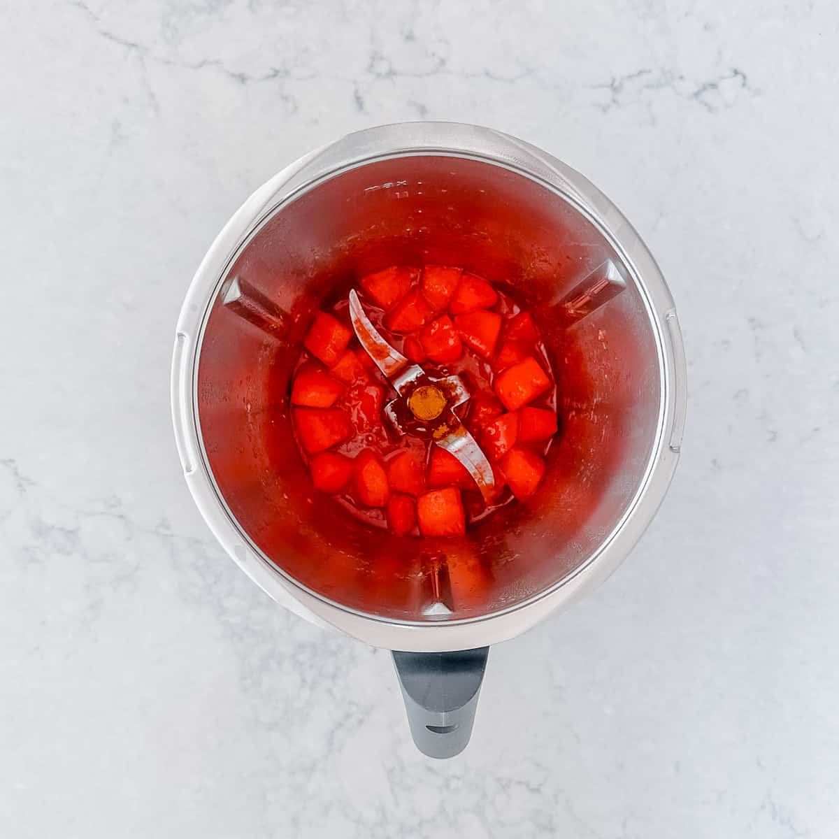 Overhead image of stewed apples and raspberries in a Thermomix Bowl.