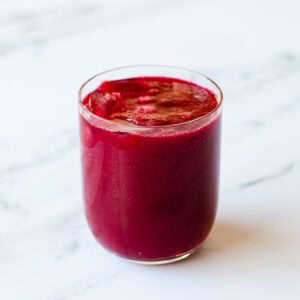 Beetroot juice sitting on a marble kitchen benchtop.