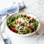 Beetroot and feta salad in a white bowl, sitting on a marble benchtop.
