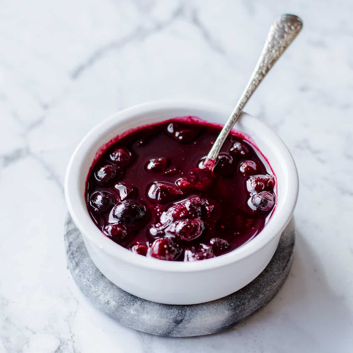 Homemade Blueberry Compote in white bowl with spoon