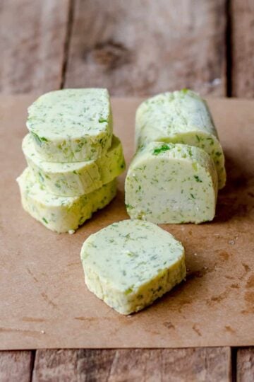Homemade Garlic Parsley Butter cut into slices on brown paper