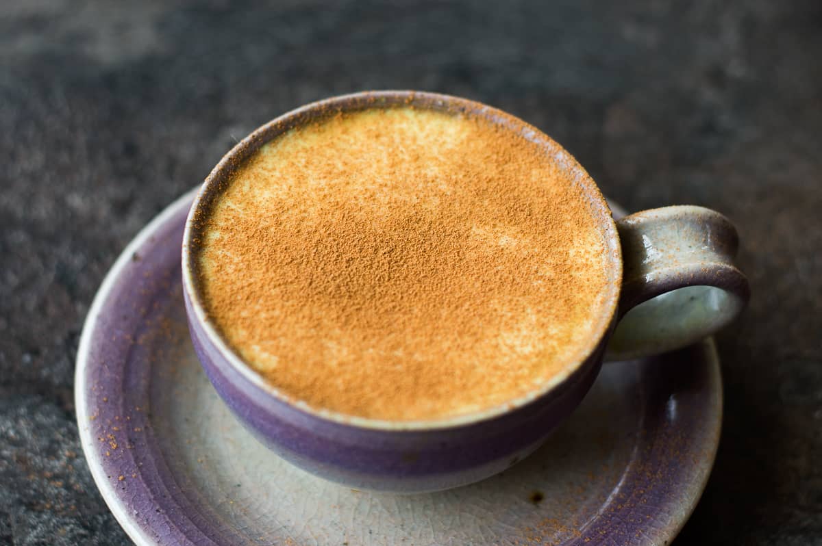 Close up Image of Turmeric Coffee Latte Spinkled with Cinnamon