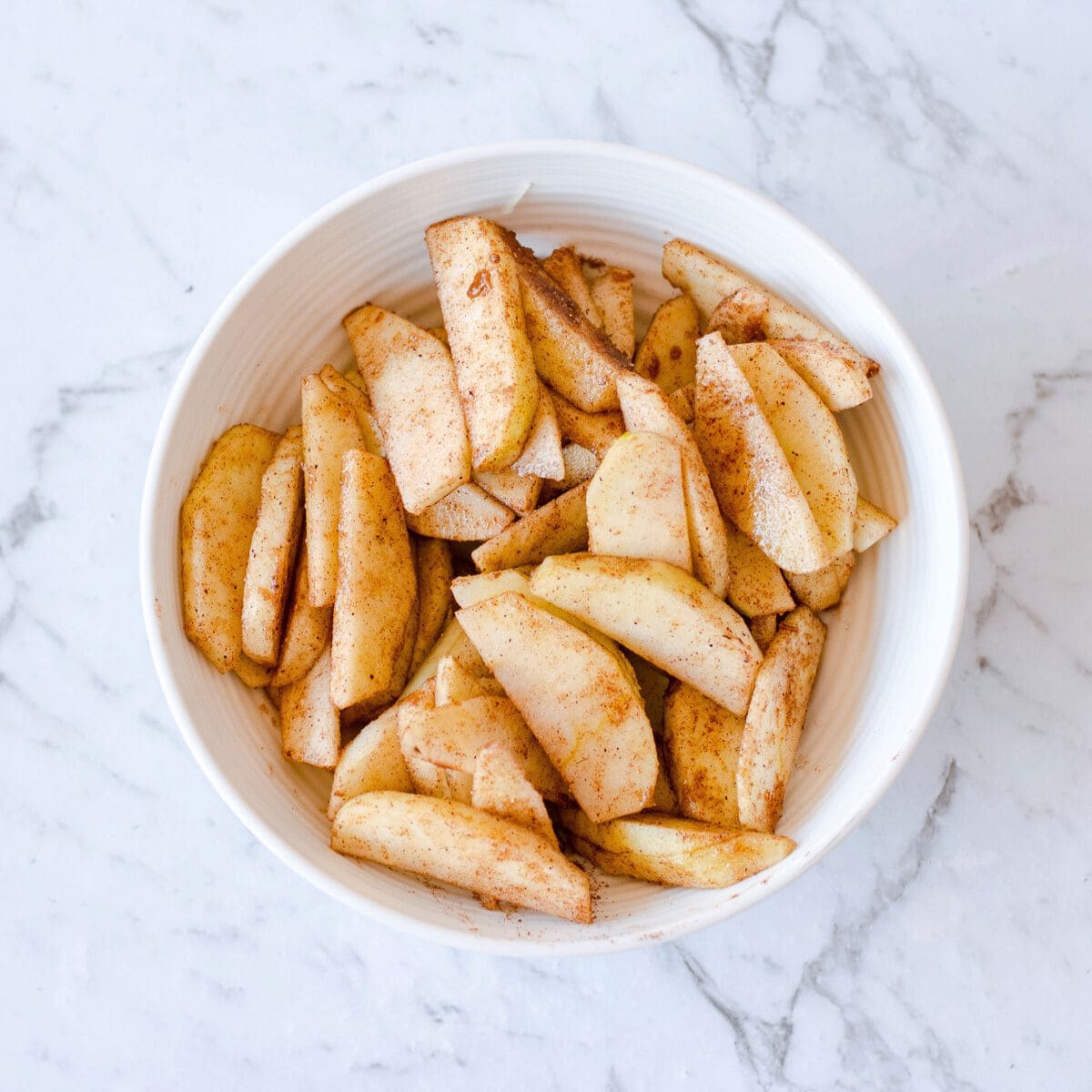 Cinnamon Apples in a white bowl.