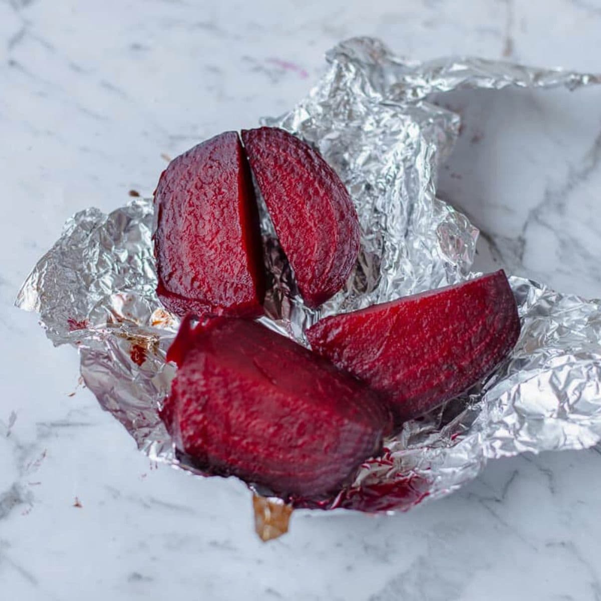 Cooked beetroot cut into quarters, wrapped in tin foil.