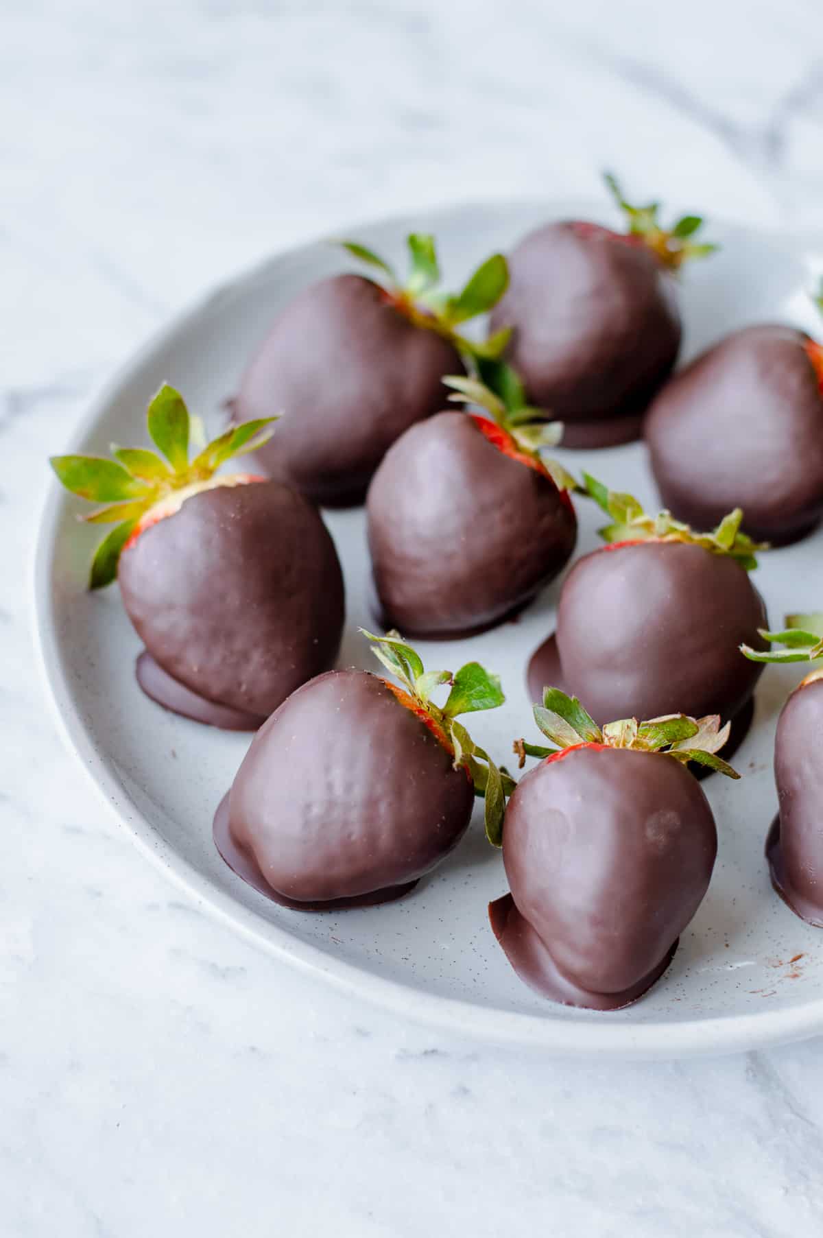 Dark chocolate covered strawberries on grey plate