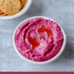 Roast Beetroot Hummus Dip in white bowl with tortilla corn chips