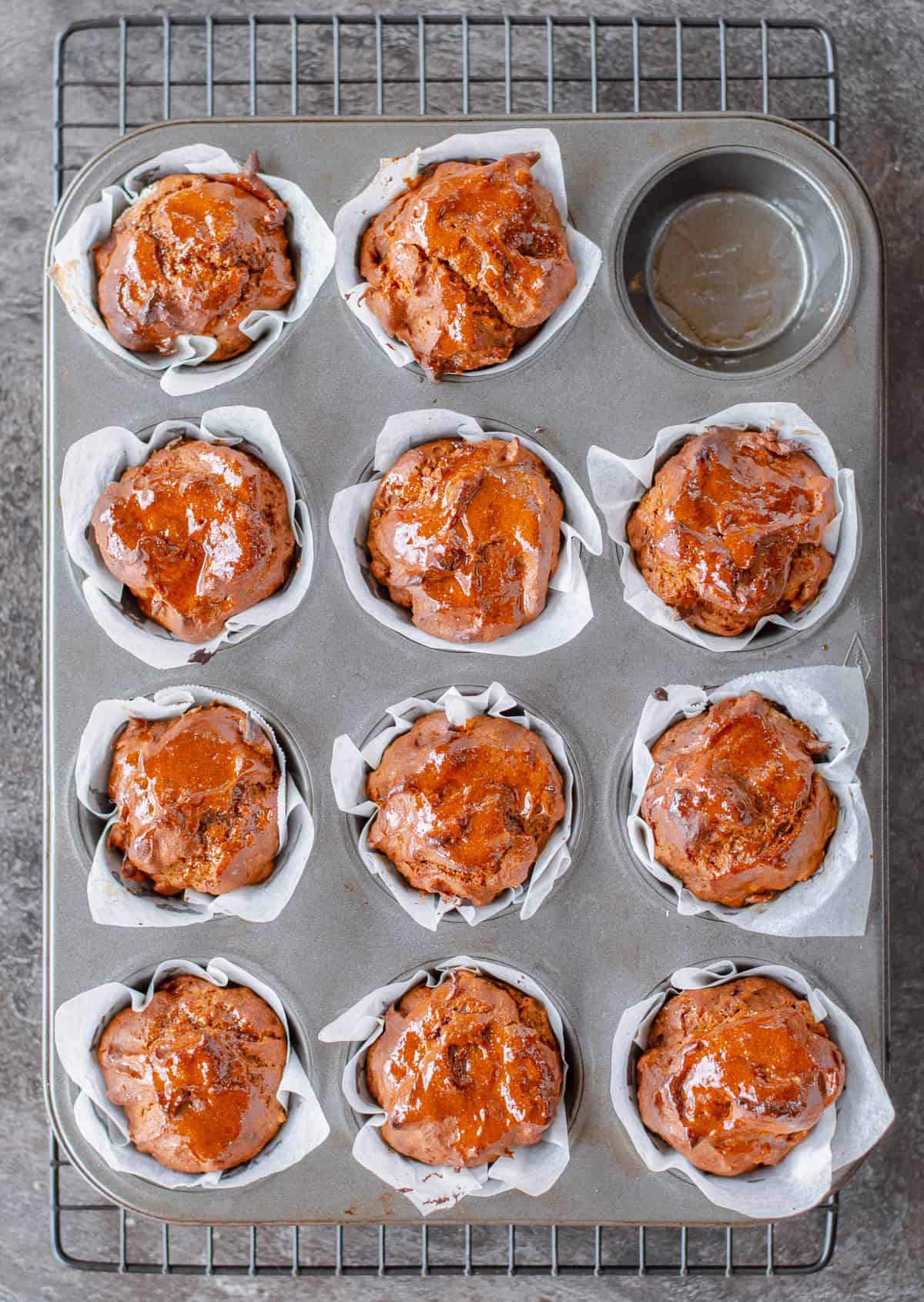 11 Muffins in a 12 hole muffin tin on baking rack