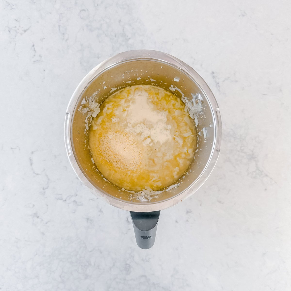 A top down view of a Thermomix containing cauliflower soup ingredients.