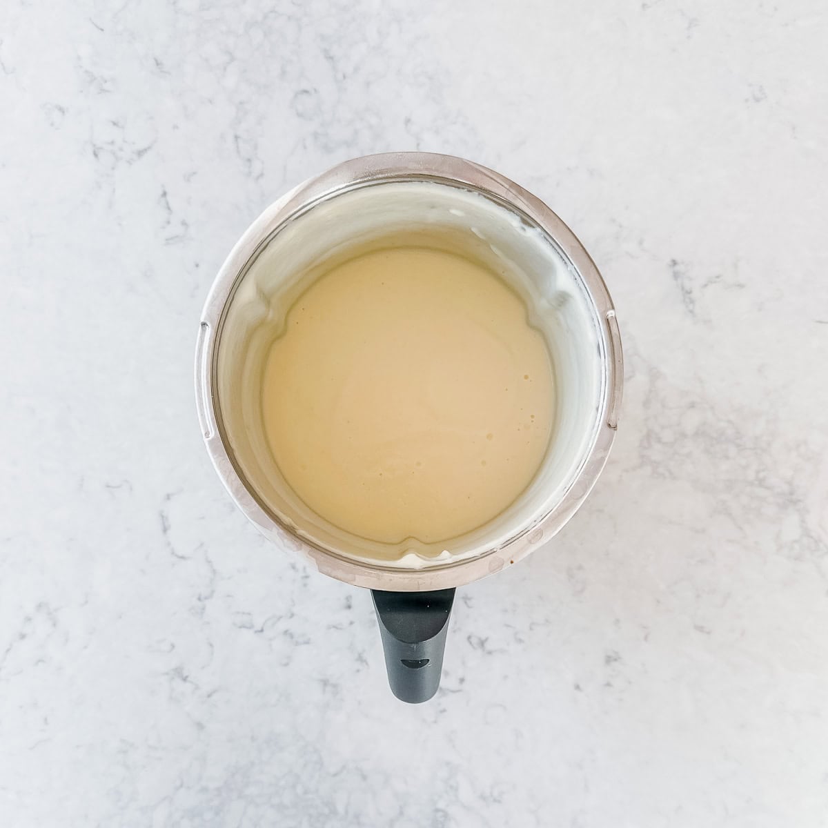 A top down view of a Thermomix jug containing blended cauliflower soup.