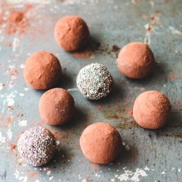 Chocolate chia bliss balls sitting on a baking sheet.