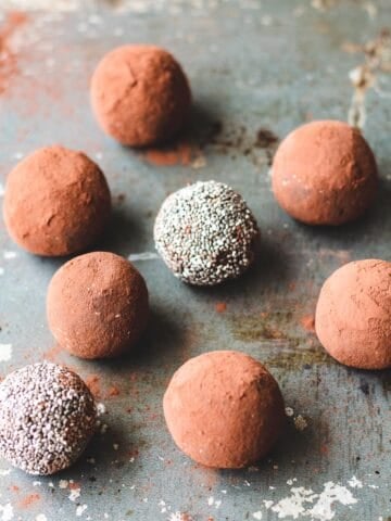 Chocolate chia bliss balls sitting on a baking sheet.