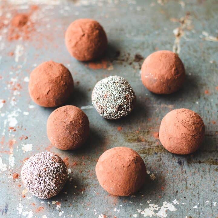 Chocolate chia bliss balls sitting on a baking sheet.