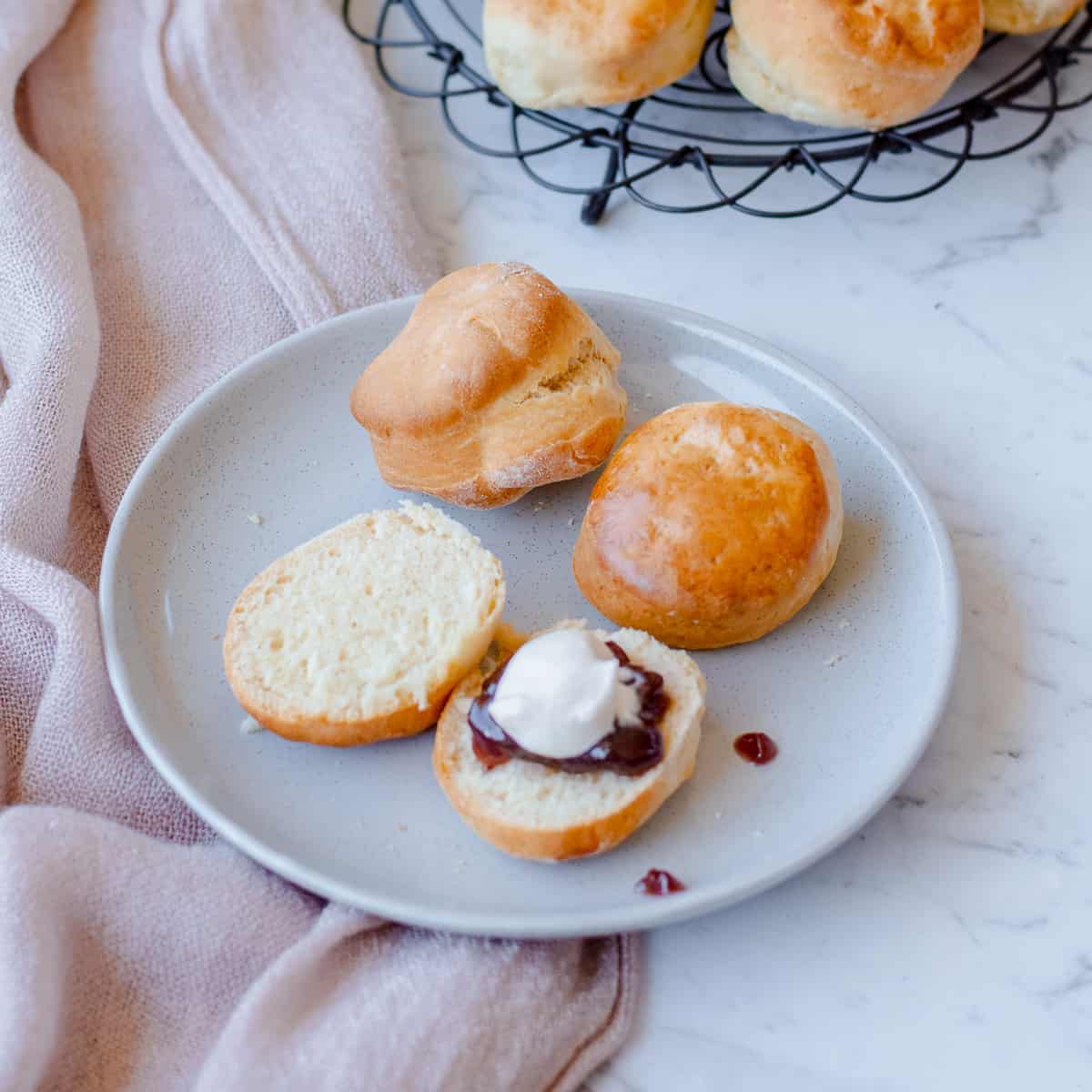 Lemonade scones on a blue plate with cream and jam