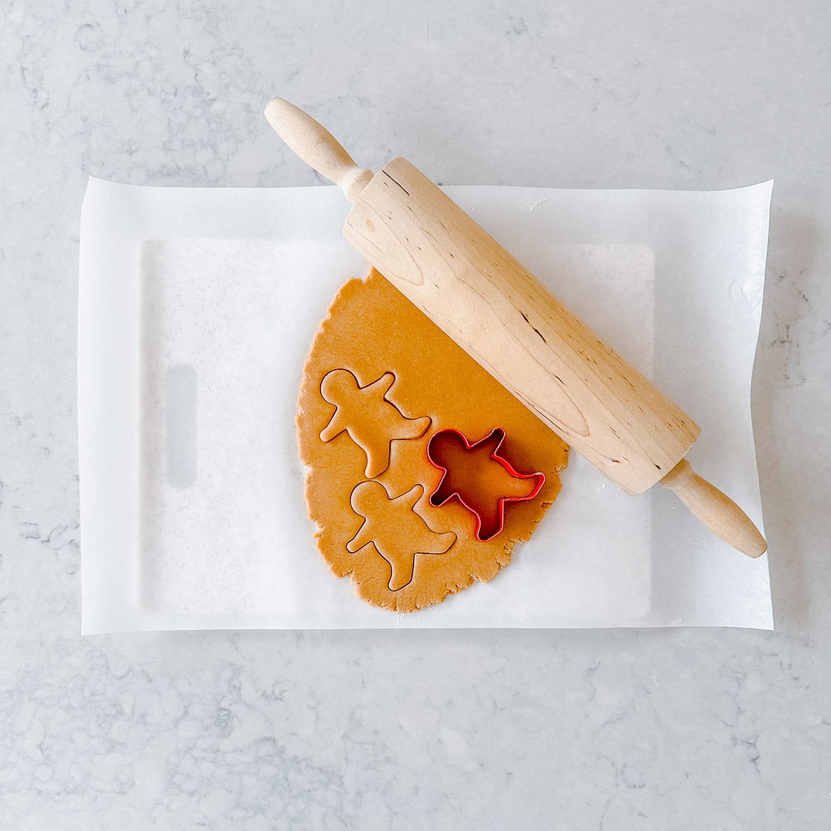 Gingerbread dough rolled out and cut into gingerbread men.