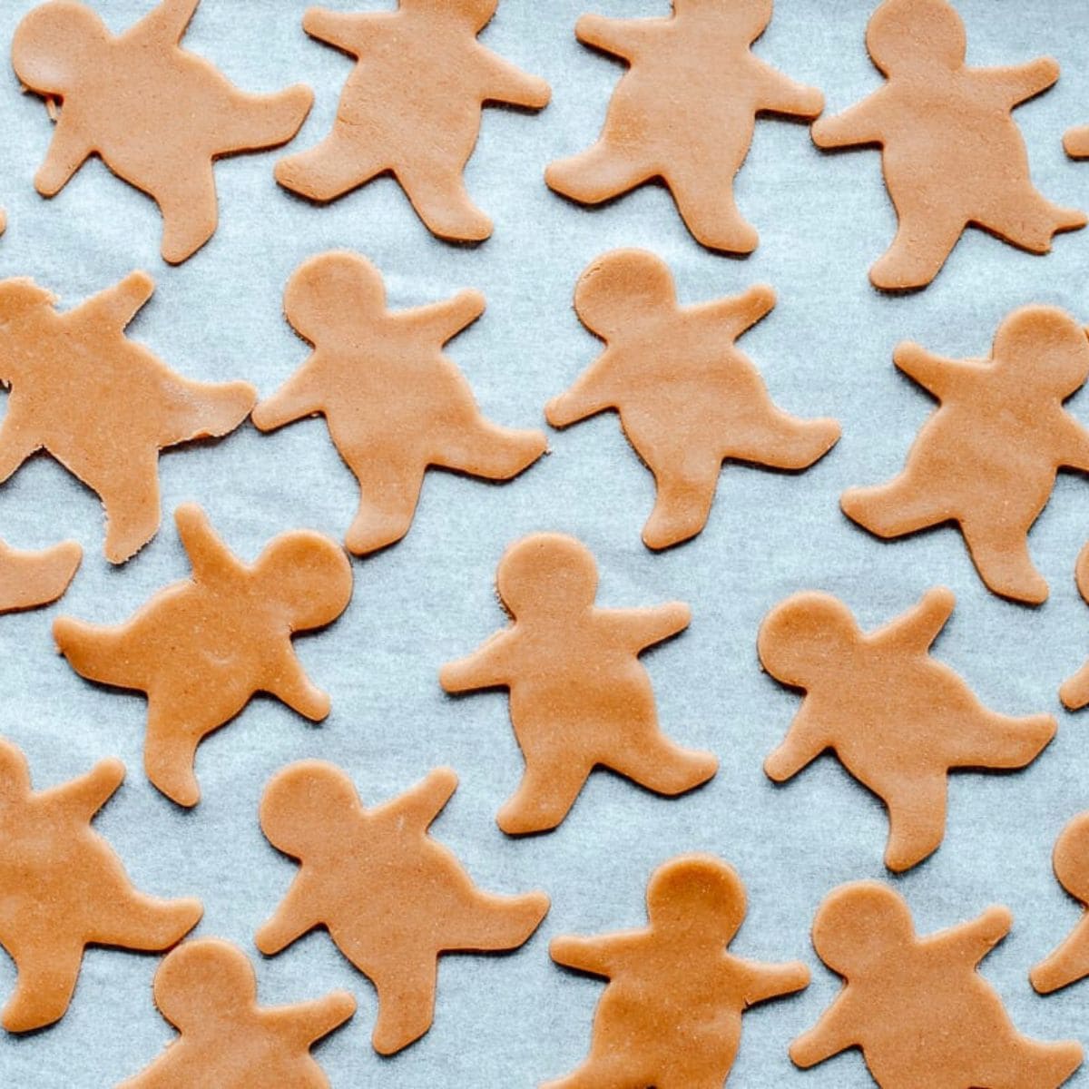 Raw gingerbread men on a baking tray.