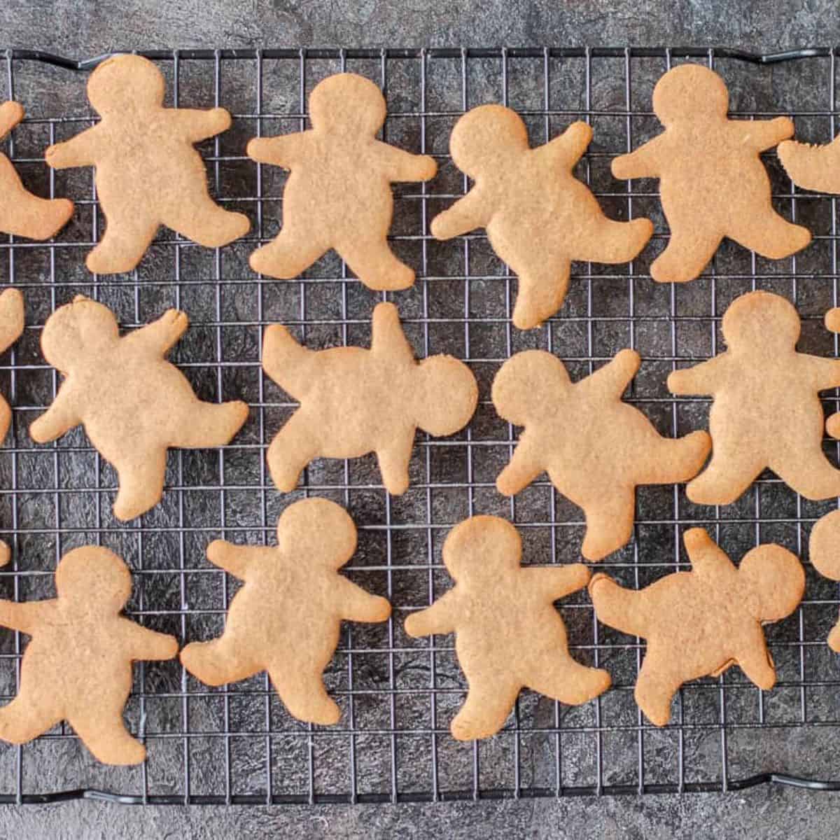 Baked gingerbread men cooling on a wire rack.
