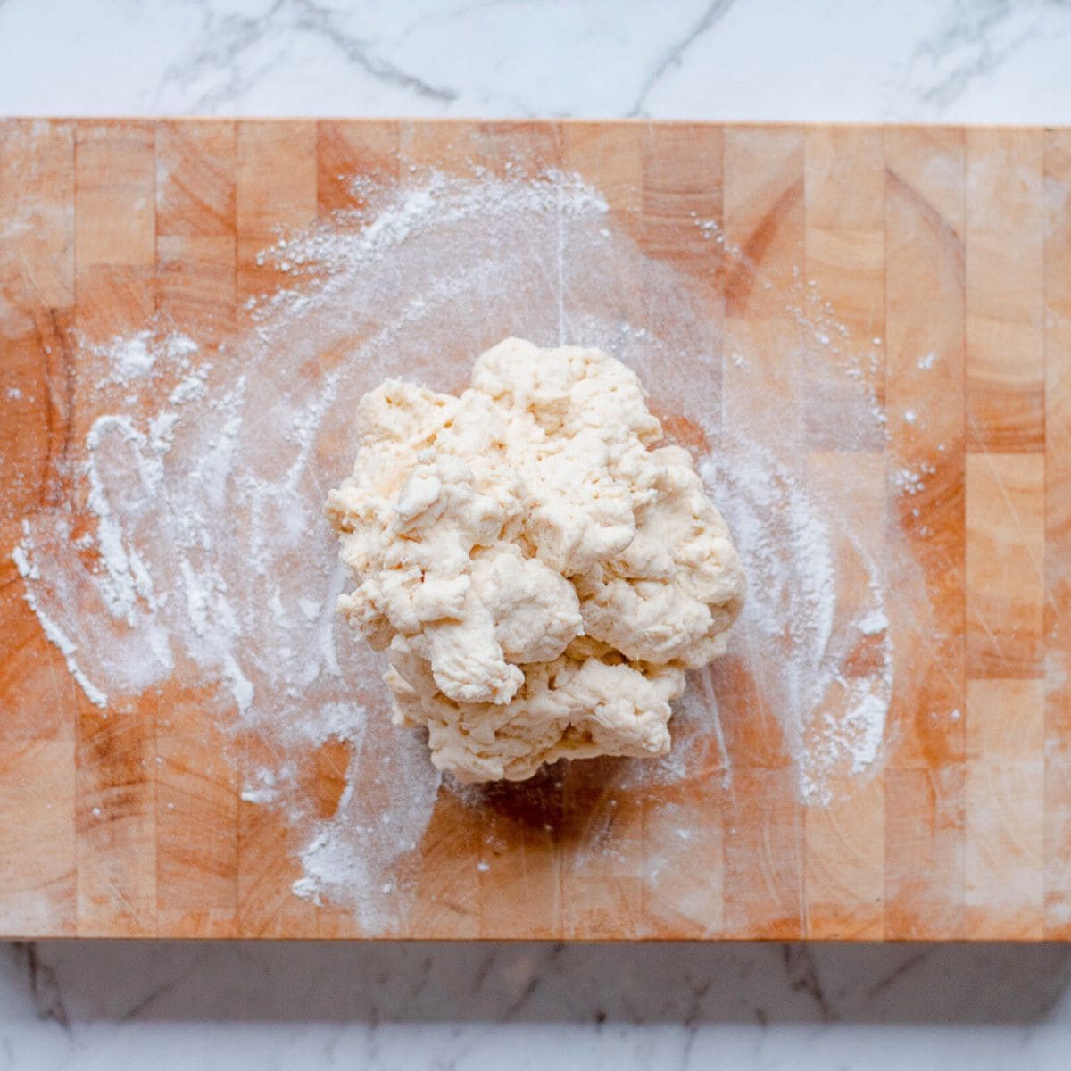 Naan dough on a wooden board.