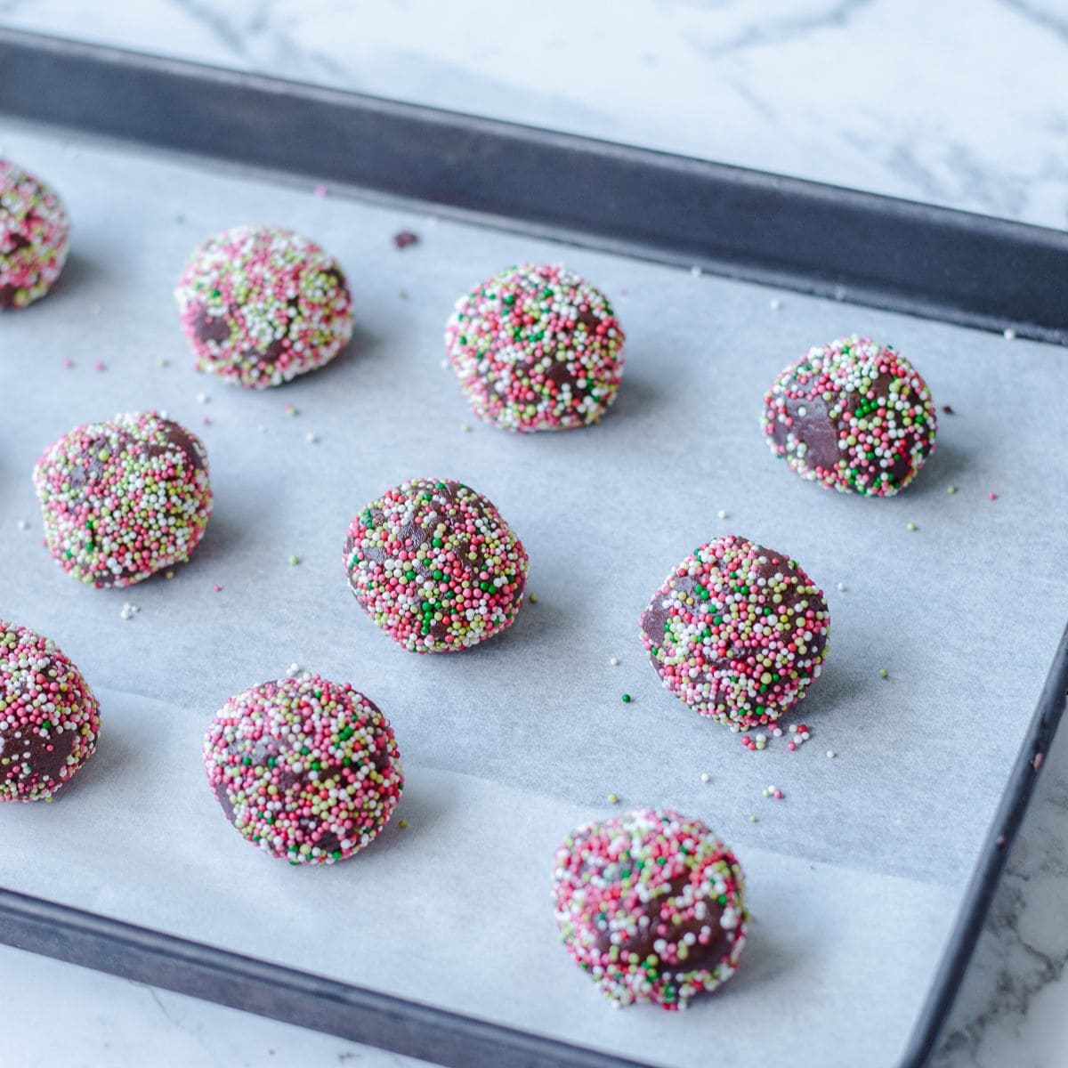 cookie dough balls on a baking tray waiting to be baked.